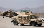 Un hélicoptère des forces afghanes et un véhicule militaire stationnés sur l'aéroport de Kaboul le 14 septembre 2021 