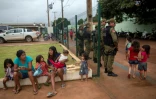 Des forces de l'ordre brésiliennes et des indigènes patientent dehors lors d'une réunion publique entre des représentants officiels et des chefs de tribus de la zone Xingu à Altamira, le 12 mars 2019