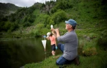Dirk Schmeller, enseignant-chercheur et Pauline Benzi, étudiante, prélèvent des échantillons d'eau dans le lac Labant, le 23 juin 2022 à Aulus-les-Bains, en Ariège
