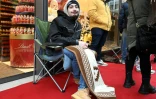 L'étudiant Leon Fehnle assis à l'avant de la file d'attente pour être le premier client à acheter l'une des 100 tablettes de chocolat de Dubaï mises en vente dans la boutique Lindt de Stuttgart, le 15 novembre 2024 en Allemagne