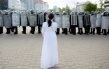 Une opposante face à des membres des forces de sécurité durant une manifestation à Minsk le 13 septembre 2020