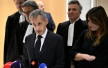 L'ex-président Nicolas Sarkozy (au centre) parle à la presse, accompagné de son épouse Carla Bruni (à droite) et de l'avocat Jean-Michel Darrois (deuxième à gauche) au tribunal à Paris, le 25 septembre 2025