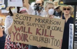 Des manifestants tiennent une pancarte "Scott Morrison ton soutien pour le charbon tuera tes enfants aussi!" à Sydney le 19 décembre 2019