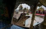 Des ouvriers déplacent une statue de Bouddha sur le site de la pagode de Kyeik Than Lan, en Birmanie, endommagé par un glissement de terrain, le 18 juin 2018