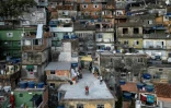Vue aérienne d'une touriste se faisant filmer par un drone sur le toit d'une maison dans la favela de Rocinha, à Rio de Janeiro, au Brésil, le 5 mars 2026