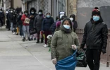 Des personnes font la queue à une distribution caritative de nourriture dans le quartier du Queens, le 29 avril 2020 à New York