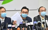 Le militant prodémocratie Alvin Yeung (c) montre l'avis de disqualification de sa candidature aux législatives lors d'une conférence de presse, le 30 juillet 2020 à Hong Kong