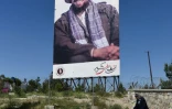 Un cycliste passe devant une affiche de Massoud le 13 mai 2019 Ă Kaboul