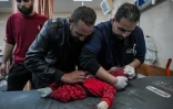 Un médecin palestinien examine un enfant sorti des décombres d'une maison touchée par un bombardement israélien à l'hôpital Al-Aqsa, à Deir al-Balah, dans le centre de la bande de Gaza, le 12 mars 2024