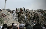 Un soldat américain tire en l'air devant une foule d'Afghans bloqués par des barbelés sur une route à proximité de la zone militaire de l'aéroport de Kaboul, le 20 août 2021