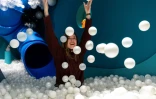 Andrea Golubic, fondatrice du musée du rire HaHaHouse, s'amuse dans une piscine à balles blanches, le 21 janvier 2025 à Zagreb, en Croatie