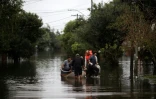Des personnes empruntent un bateau pour traverser une rue inondée à Porto Alegre, dans l'Etat du Rio Grande do Sul, au Brésil, le 12 mai 2024