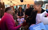 La Première ministre, Elisabeth Borne (d), distribue des tracts de campagne à des habitants, le 28 mai 2022 à Aunay-sur-Odon, dans le Calvados