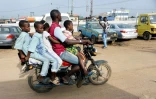 Une moto-taxi transporte quatre enfants, sans casques, dans les rues de Lagos, le 4 septembre 2019 au Nigeria