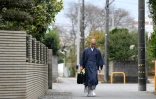 Kaichi Watanabe, un moine bouddhiste (D) marchant dans une rue de Funabashi, une banlieue de Tokyo le 10 novembre 2016