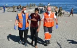 Des membres de la Croix rouge assistent un migrant arrivé à la nage à l'enclave espagnole de Ceuta, le 18 mai 2021
