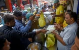 Des personnes achètent du biryani dans un restaurant de Karachi, le 16 septembre 2023 au Pakistan