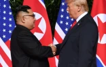 Le leader nord-coréen Kim Jong Un (g) et le président américain Donald Trump se serrent la main, le 12 juin 2018 à l'hôtel Capella sur l'île de Sentosa, à Singapour