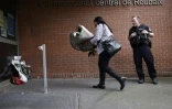 Une femme dépose un bouquet de fleurs devant le commissariat de police de Roubaix (Nord) en homme aux policiers tués dans un accident de la route, le 21 mai 2023