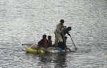 Des enfants utilisent un radeau pour se frayer un chemin dans une zone inondée après de fortes pluies de mousson dans la banlieue de Sukkur, dans la province du Sindh, au Pakistan, le 27 août 2022