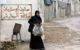 Une femme porte un sac de petit bois dans le camp pour déplacés syriens d'Atmé, dans la province d'Idleb, dans le nord-ouest de la Syrie, le 5 février 2025