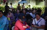 Des parents et proches attendent des nouvelles devant la grotte de Tham Luang, le 26 juin 2018 à Chiang Rai, en Thaïlande