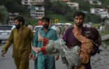 Un homme porte sa fille malade le long d'une route endommagée par les eaux de crue suite aux fortes pluies de mousson dans la région de Madian, dans la vallée de Swat, au nord du Pakistan, le 27 août 2022