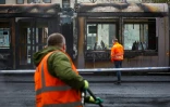 Des agent regardent un tramway incendié le 24 novembre 2023 à Dublin