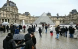 Des visiteurs devant le musée du Louvre et la pyramide conçue par l'architecte sino-américain Ieoh Ming Pei, fermés lors d'un mouvement de grève, le 12 janvier 2026 à Paris