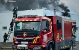 Photo diffusée par le service d'urgence de l'État ukrainien, le 18 mai 2025, de sauveteurs éteignant un incendie dans un bâtiment à la suite d'attaques de drones russes sur la région de Kiev