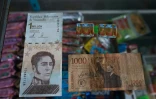 Billet d'un million de bolivars vénézuéliens (g) et son équivalent de 1000 pesos colombiens (d) dans une épicerie de Puerto Concha au Venezuela le 8 septembre 2021