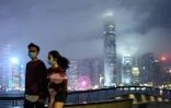 Un couple portant des masques de protection contre le nouveau coronavirus à Tsim Sha Tsui, à Hong Kong, le 14 février 2020