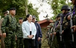 La Première ministre thaïlandaise Paetongtarn Shinawatra passe en revue les troupes dans la base militaire de Morakot, près de la frontière cambodgienne, en compagnie du général Boonsin Padklang (à gauche) le 20 juin 2025