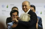 Le président de la COP21, Laurent Fabius (d) avec l'ambassadrice française Laurence Tubiana (de dos) et la responsable climat de l'ONU Christiana Figueres (g), à Paris le 12 décembre 2015