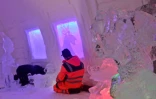 Un employé apporte la touche finale à une pièce du Arctic Snow Hotel, un hôtel fait de glace, le 17 décembre 2020 à Rovaniemi, en Laponie finlandaise
