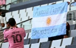 Un supporteur de l'Inter Miami tient un drapeau argentin portant un message de soutien pour Lionel Messi à la suite de la mort de son père, le 8 août 2026 à Miami
