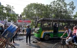 Un policier à côté d'un bus incendié par des militants du Parti nationaliste du Bangladesh (BNP) lors d'un rassemblement dans le cadre d'une grève nationale, le 29 octobre 2023 à Dacca, au Bangladesh