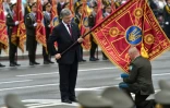 Le commandant d'une unité rend hommage au drapeau que lui tend le président ukrainien Petro Porochenko, à Kiev, le 24 août 2016