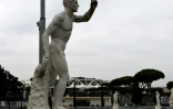 Une statue à l'extérieur du stade olympique (en arrière plan) de Rome le 17 mars 2020