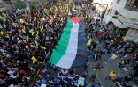 Des partisans du mouvement libanais Hezbollah défilent avec un drapeau palestinien géant à Beyrouth le 11 décembre 2017