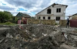 Un cratère devant une maison endommagée de la localité ukrainienne de Siversk, dans la région de Donetsk, prise entre les tirs des forces de Kiev et celles de Moscou, le 7 septembre 2022.
