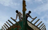 Des ouvriers travaillent sur un bateau de pêche dans le port de Kasimedu, le 10 juin 2021 en Inde