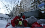 Des fleurs ont été déposées aux abords de l'immeuble touché  par une explosion au gaz à Magnitogorsk, en Russie, en hommage aux victimes, le 1er janvier 2019