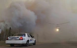 Une photo fournie par la police montée d'Alberta au Canada, montrant une voiture de police et un hélicoptère pris dans le nuage de fumée des incendies de Fort McMurray, le 7 mai 2016