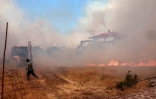 Une personne fuit un un incendie qui se rapproche du village de Vatera, dans l'est de la station balnéaire populaire de l'île grecque de Lesbos, le 23 juillet 2022