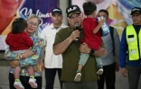 Le ministre vénézuélien de l'Intérieur Diosdado Cabello s'exprime en portant un enfant rapatrié aux côtés de la Première Dame Cilia Flores après l'arrivée d'un avion transportant des migrants vénézuéliens rapatriés des États-Unis à l'aéroport international Simon Bolivar à Maiquetia, au Venezuela, le 18 juillet 2025