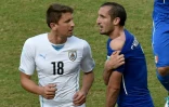 Le défenseur italien Giorgio Chiellini (d) montre la morsure à l'épaule infligée par le milieu uruguayen Luis Suarez (g) au Mondial, le 24 juin 2014 à Natal au Brésil