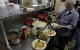 Yasser Taha, patron du restaurant palestinien Abou Choukri, prépare des assiettes de houmous, le 12 septembre 2015 à Jérusalem