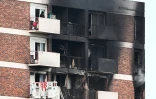 Des habitants sur leur balcon au dernier étage d'un immeuble où un incendie s'est déclaré à L'Île-Saint-Denis (Seine-Saint-Denis), le 19 août 2023 