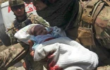 Un membre des forces de sécurité afghane porte un nouveau-né évacué d'un hôpital attaqué par des hommes armés, le 12 mai 2020 à Kaoul